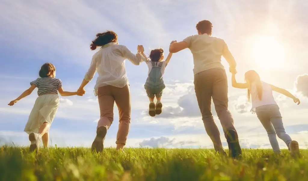 Happy family on summer walk! Mother, father and daughters walking in the Park and enjoying the beautiful nature.