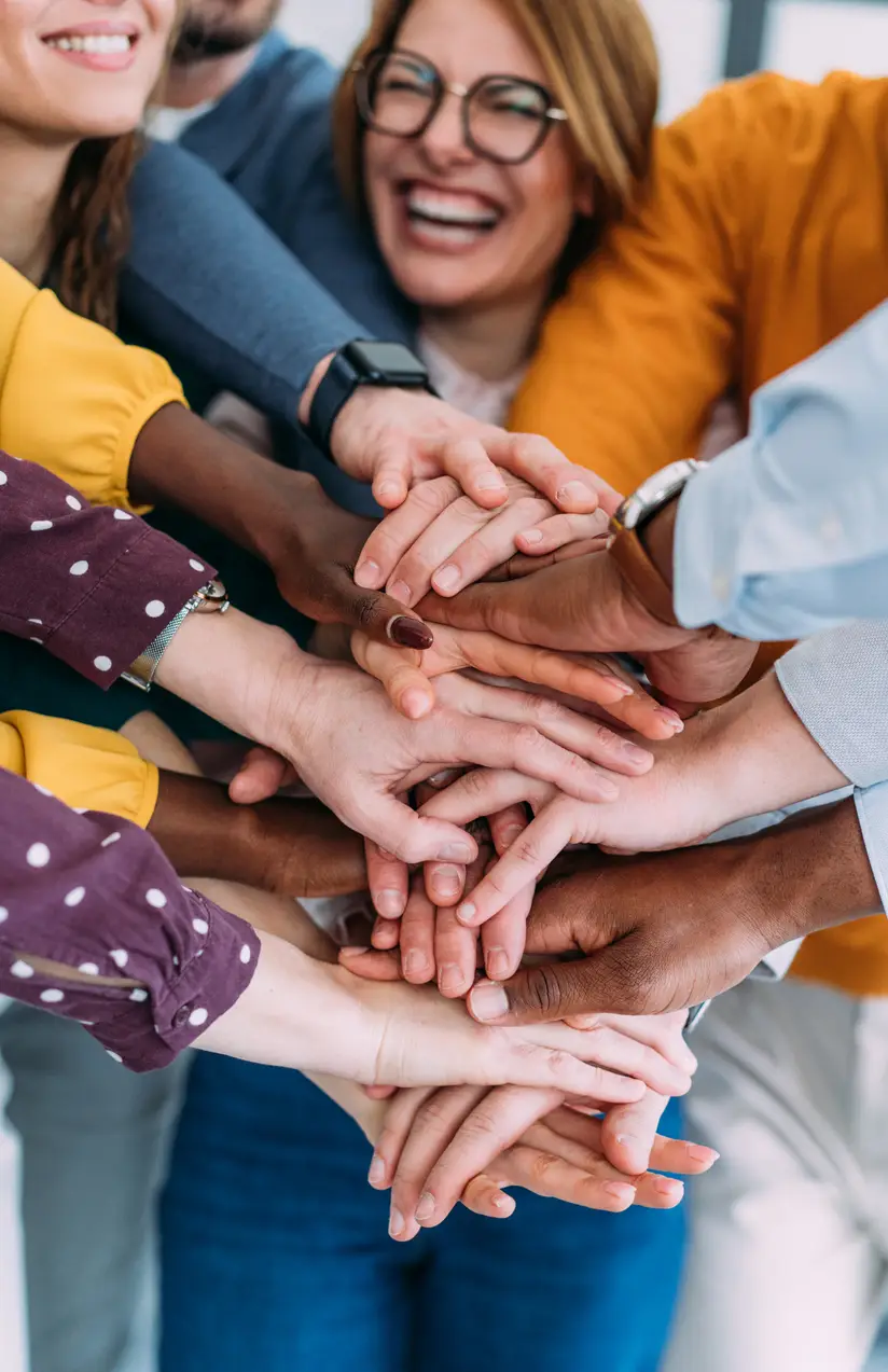 Shot of multiracial group of business people with stacked hands showing unity and teamwork. Successful business people stacking hands in the office.