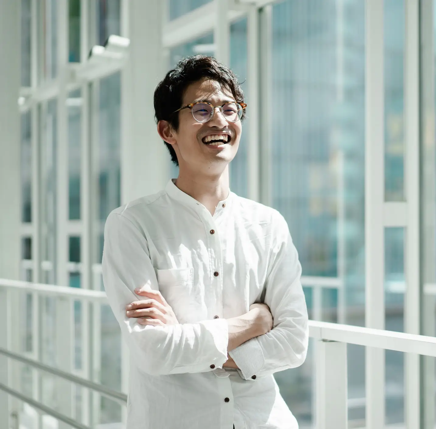 Casual business portrait of a young Asian man standing by the window. Looks like a CEO or engineer.