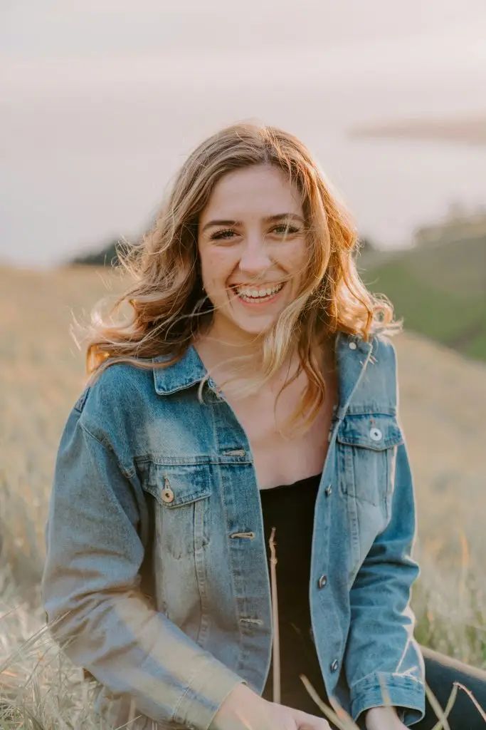 Woman smiling while sitting in a field