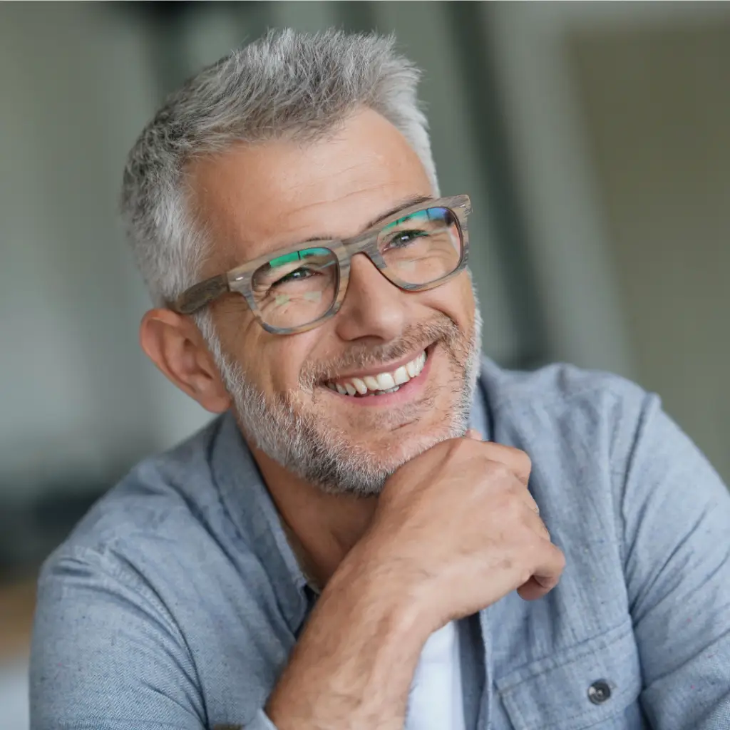Older gentleman wearing glasses and smiling serenely