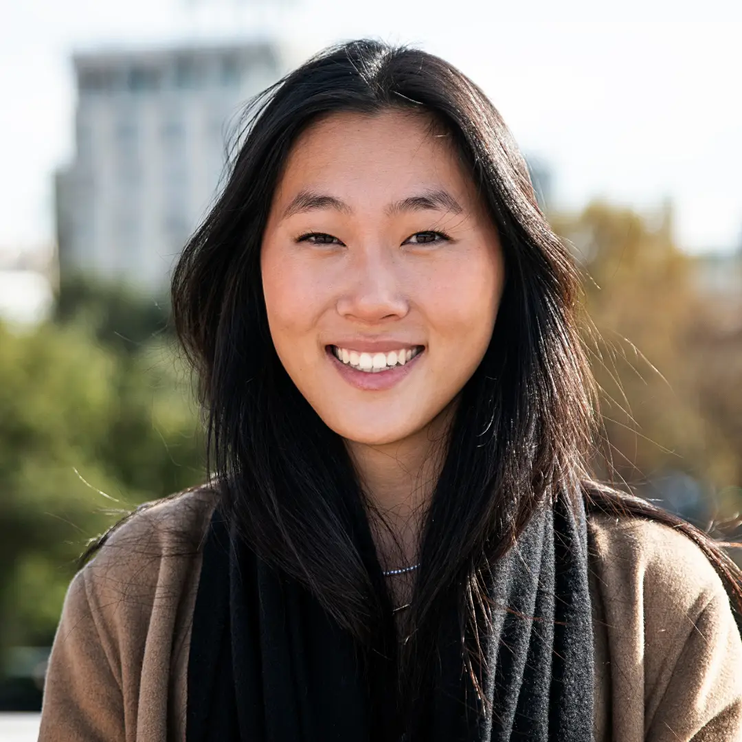 Smiling East Asian woman with the view of a city behind her