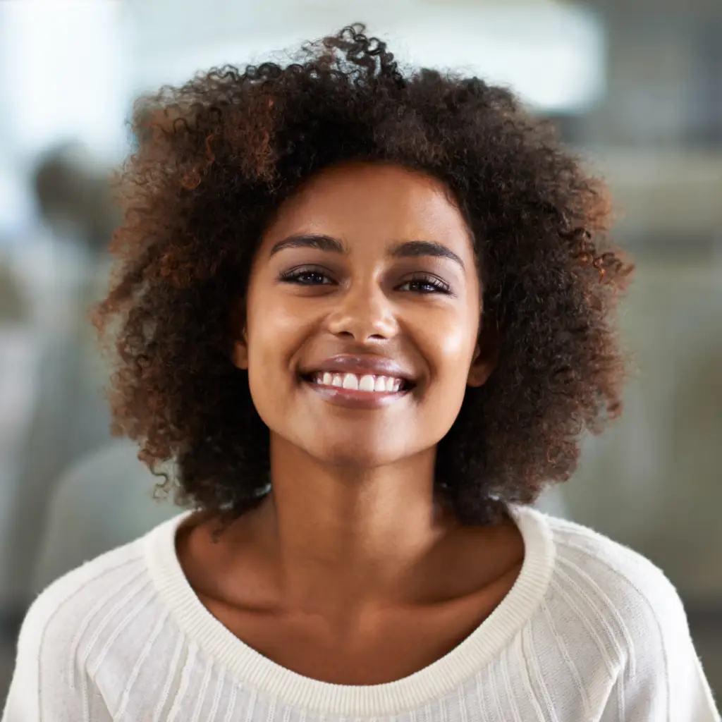 Happy woman wearing a white shirt standing and smiling.